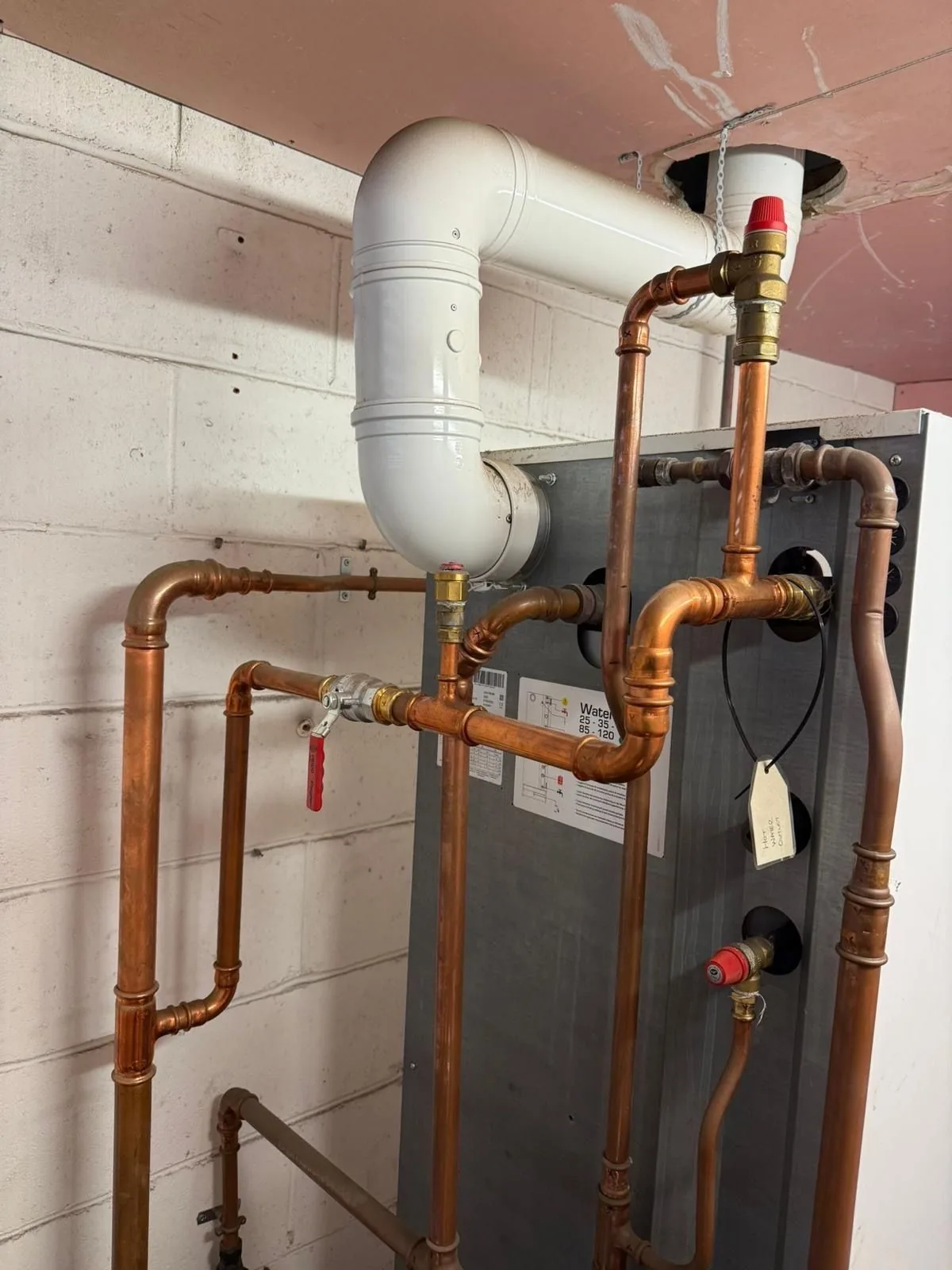 New flue and pressure-relief pipework installed for the new water heater